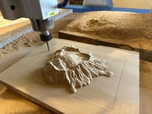 CNC machine carving a timber terrain model in the Design Eye workshop