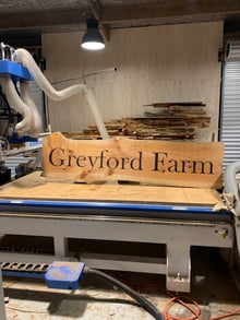 Greyford Farm live edge timber entranceway sign on the CNC machine in the Design Eye workshop